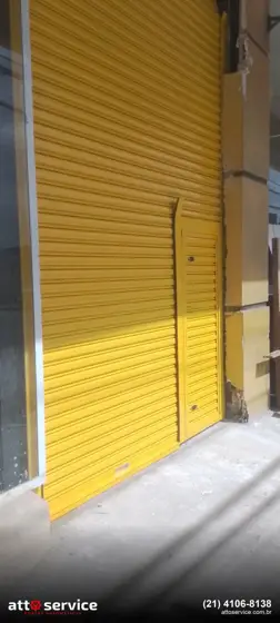 Porta de enrolar amarela com portinhola social e fechadura