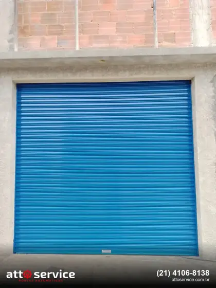 Porta de enrolar azul em garagem de sobrado