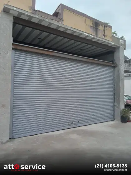 Porta de enrolar cinza em fachada comercial