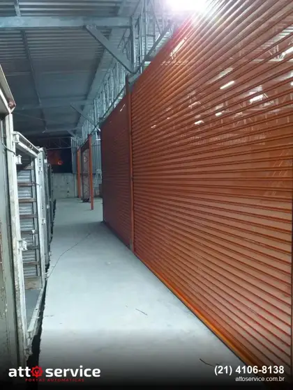 Porta de enrolar laranja em galeria comercial