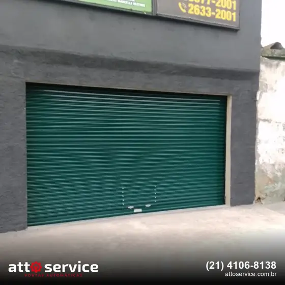 Porta de enrolar verde em fachada escura