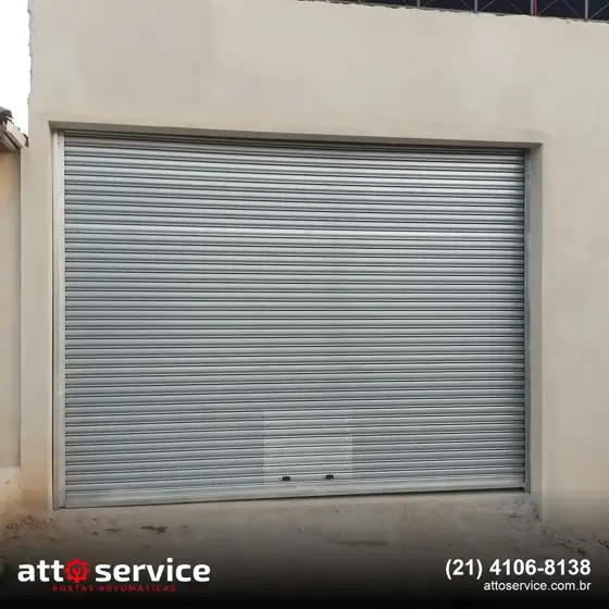 Porta de enrolar cinza em garagem de casa