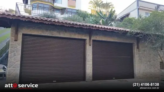 Duas portas de enrolar marrons em garagem de casa