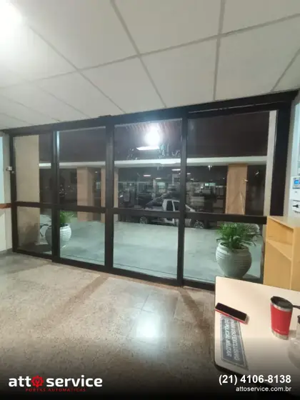 Porta de vidro deslizante com perfil preto em recepção