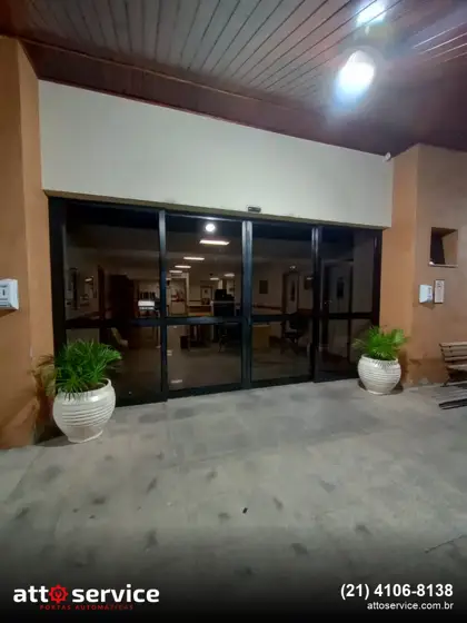 Porta de vidro deslizante com perfil preto e vasos