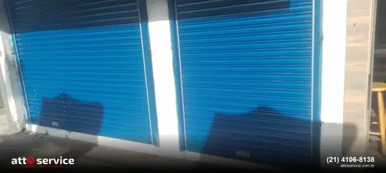 Duas portas azuis separadas por pilar branco, a social à esquerda da principal