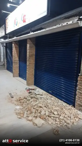 Ponto comercial com pilares de tijolo aparente e porta social azul-marinho