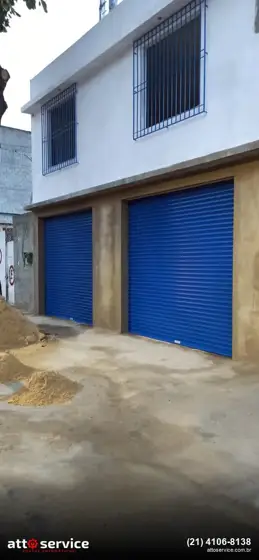 Sobrado com duas portas azuis lado a lado, a estreita para pedestres